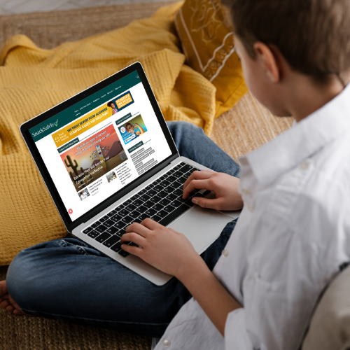 A child sitting on the floor and using a laptop to search
