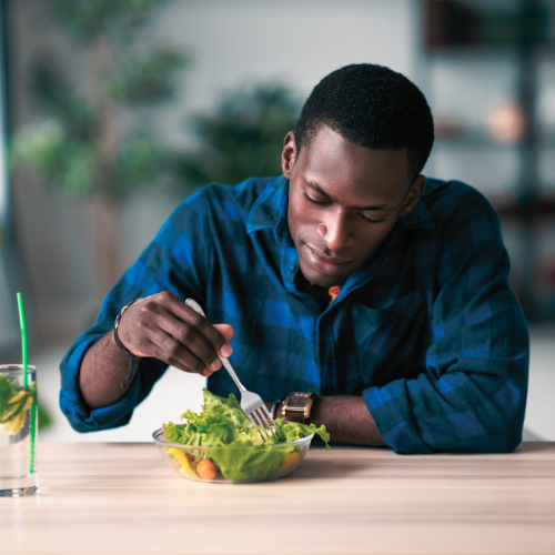A man enjoying a salad as he practices gratitude and mindful eating.