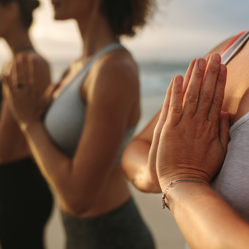 An image of people with their hands folded in front of their chest.