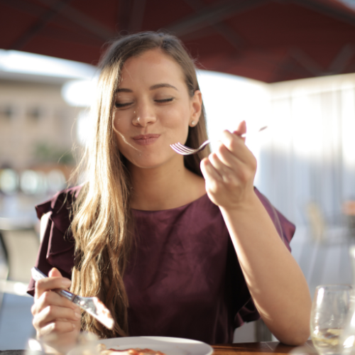 An image of a woman focusing on eating food mindfully.
