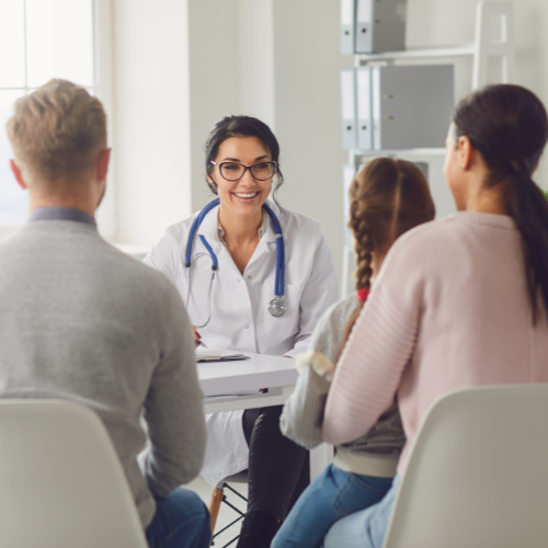 An image of a doctor speaking to a family of patients.