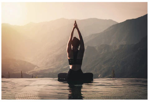 An image of a woman doing yoga in front of a mountain scape.