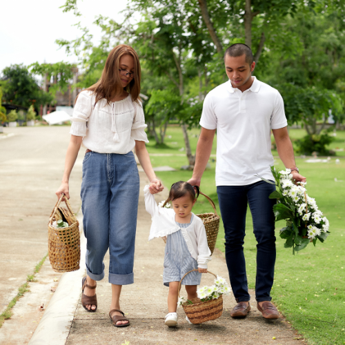 A man and a woman taking a leisurely walk with their child to strengthen their bonds.